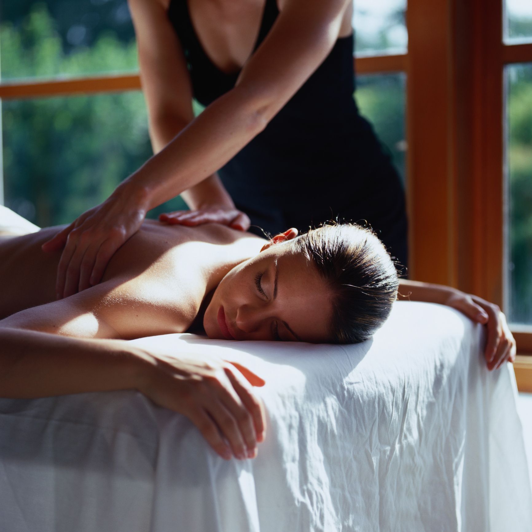 A woman is laying on a table getting a massage