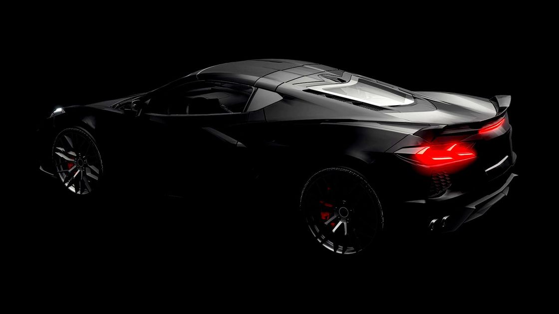 a black sports car with red lights on a black background .