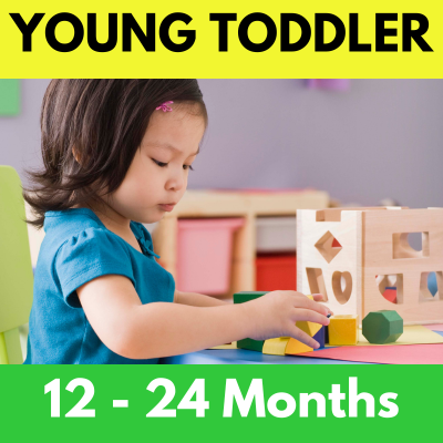 A young toddler is playing with blocks at a table