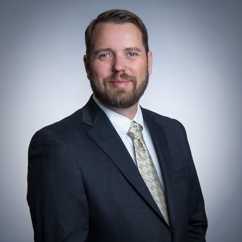 A man with a beard is wearing a suit and tie.