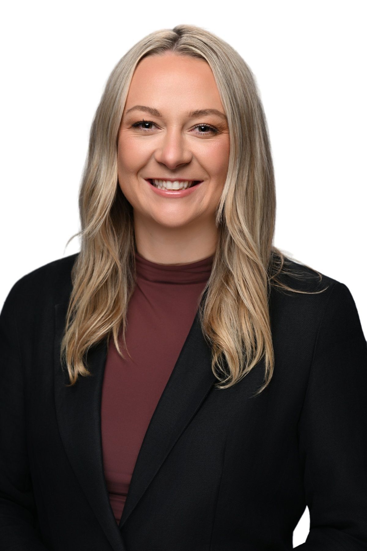 A woman in a black jacket and white shirt is smiling for the camera.