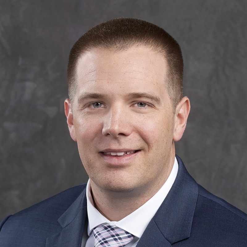 A man in a suit and tie is looking at the camera