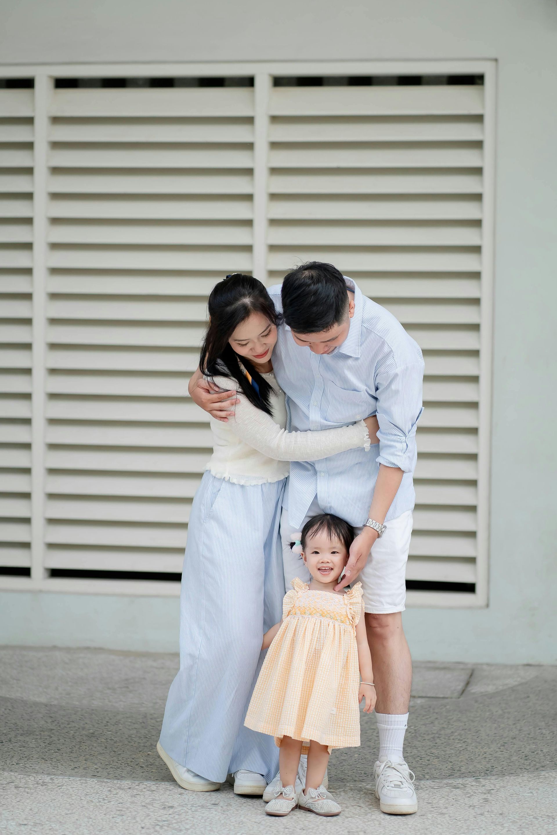 A little girl is whispering into a man 's ear.