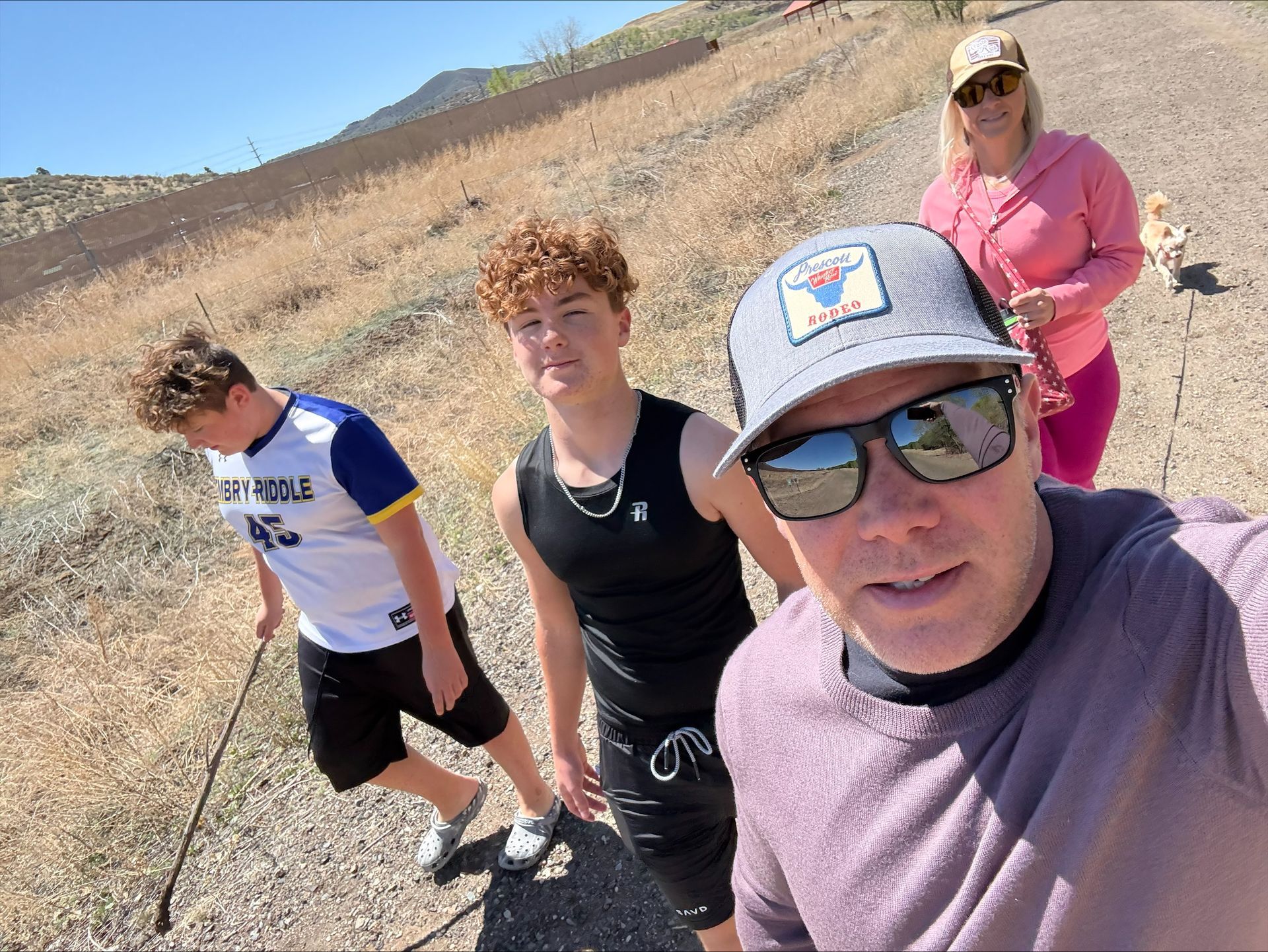 A group of people are standing on a dirt road.
