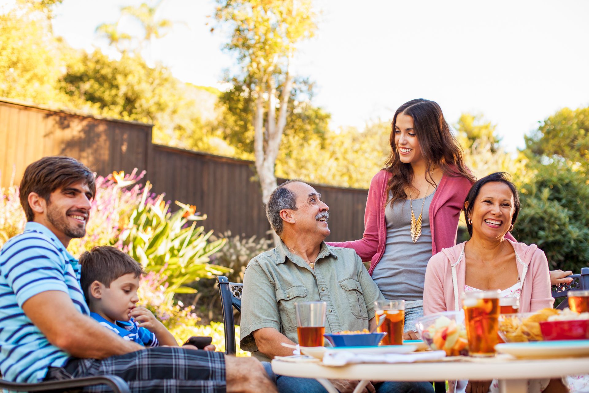 A group of people are sitting around a table eating food.