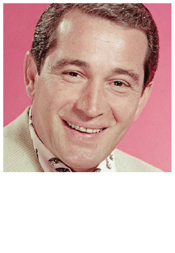 A close-up portrait of a smiling person wearing a light-colored jacket and a patterned scarf against a pink background.