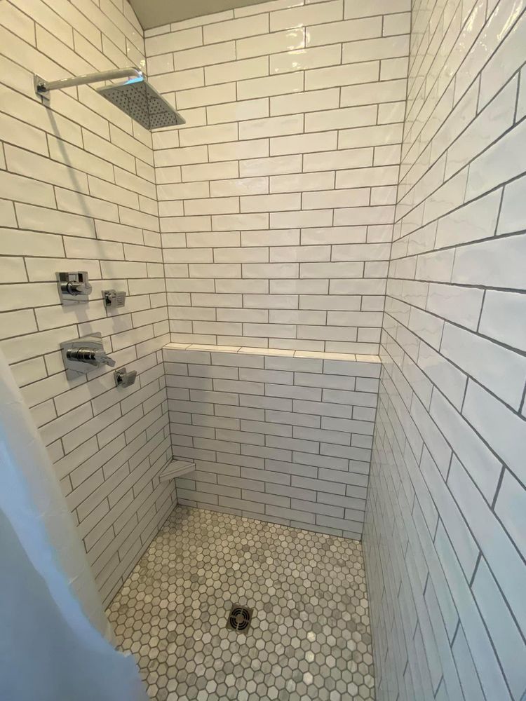 A shower with white brick walls and a tiled floor.