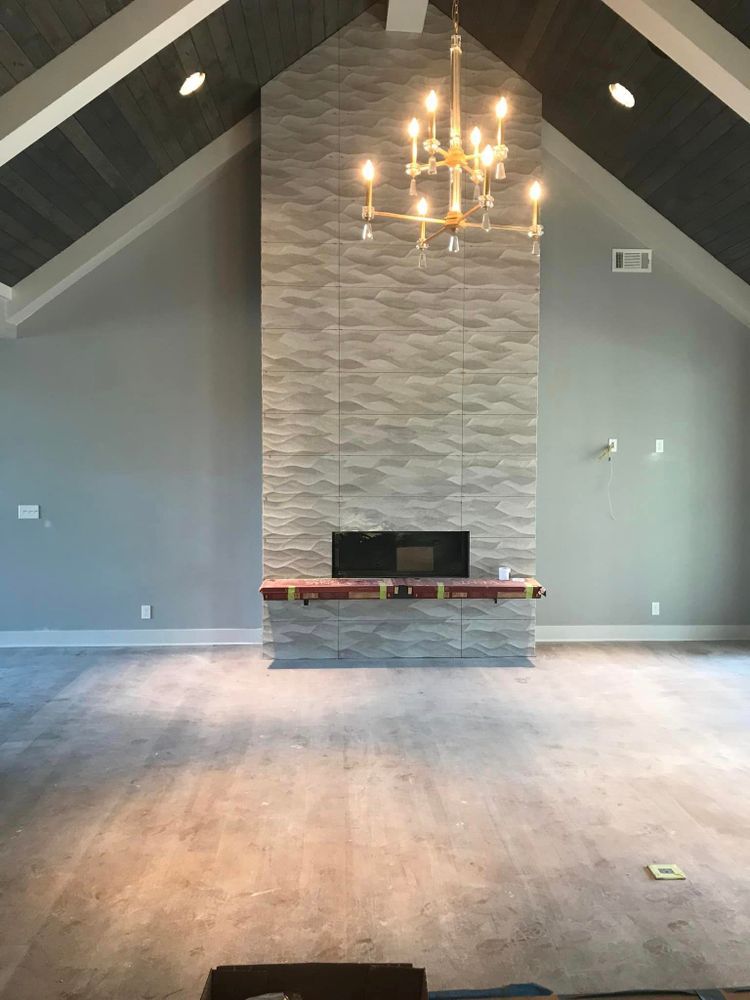 A living room with a fireplace and a chandelier hanging from the ceiling.