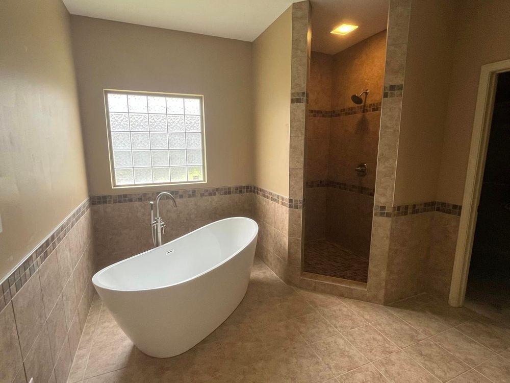 A bathroom with a bathtub and a walk in shower.
