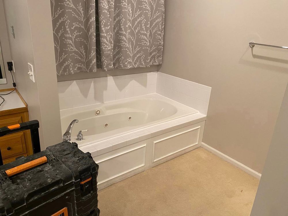 A bathroom with a jacuzzi tub and a toolbox.