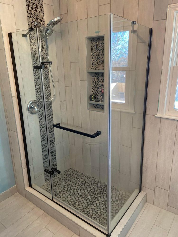 A bathroom with a walk in shower and a window.
