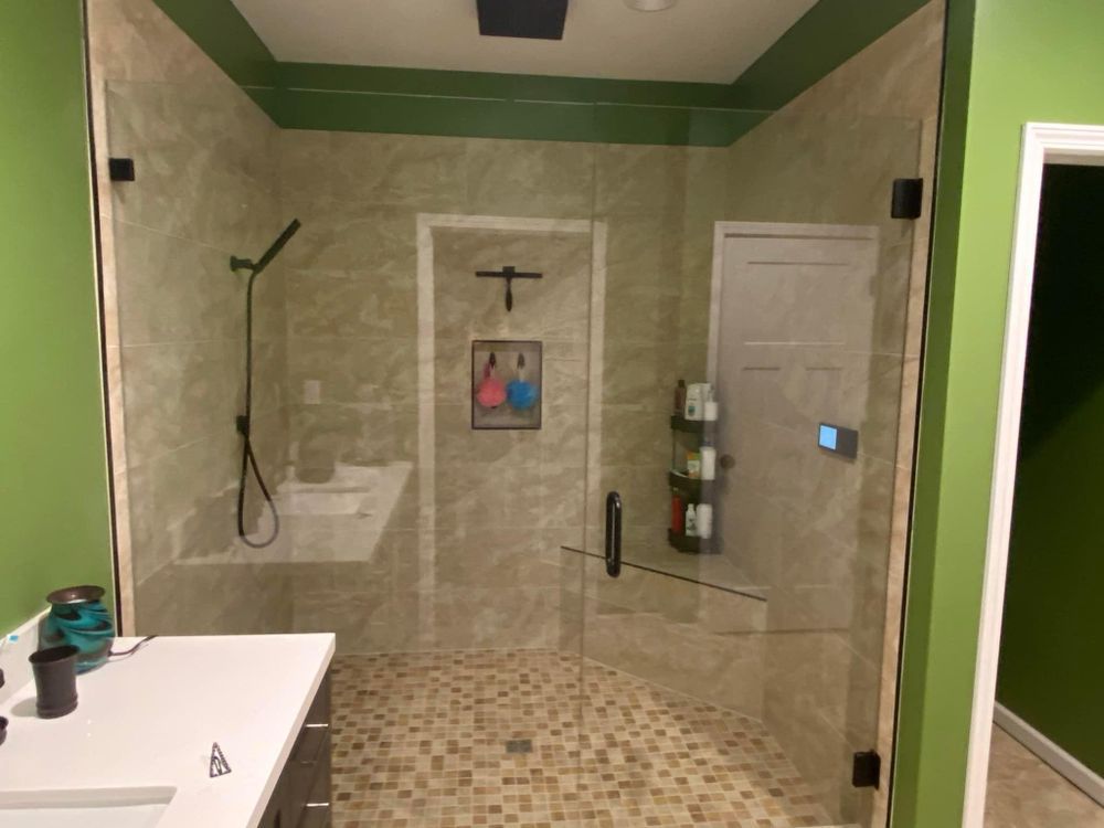 A bathroom with a walk in shower and a sink.