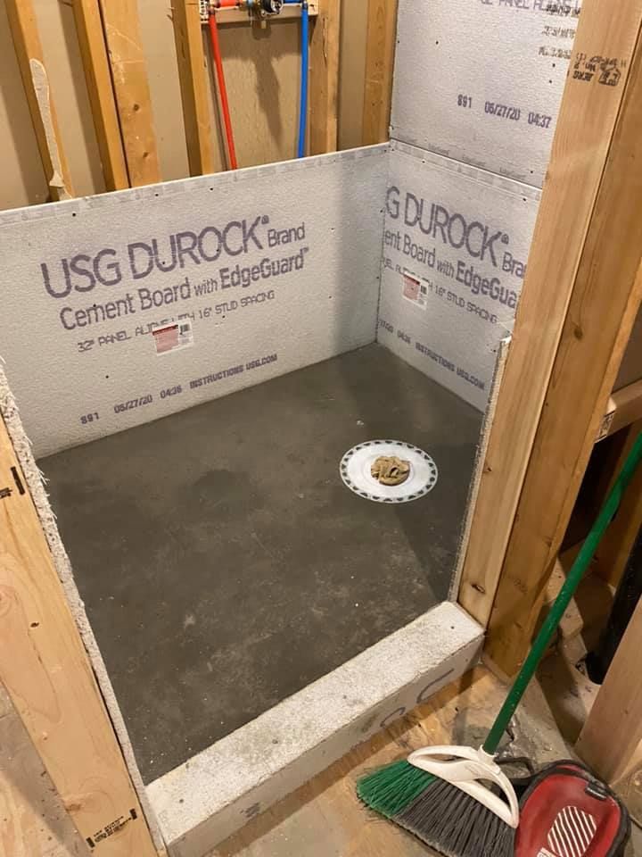 A shower stall is being built in a bathroom.