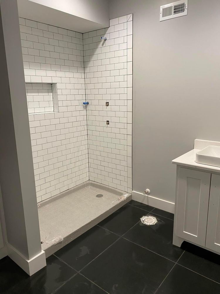 A bathroom with a walk in shower and a sink.