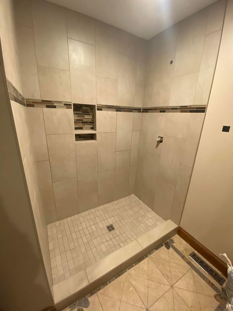 A bathroom with a walk in shower and tiled walls.