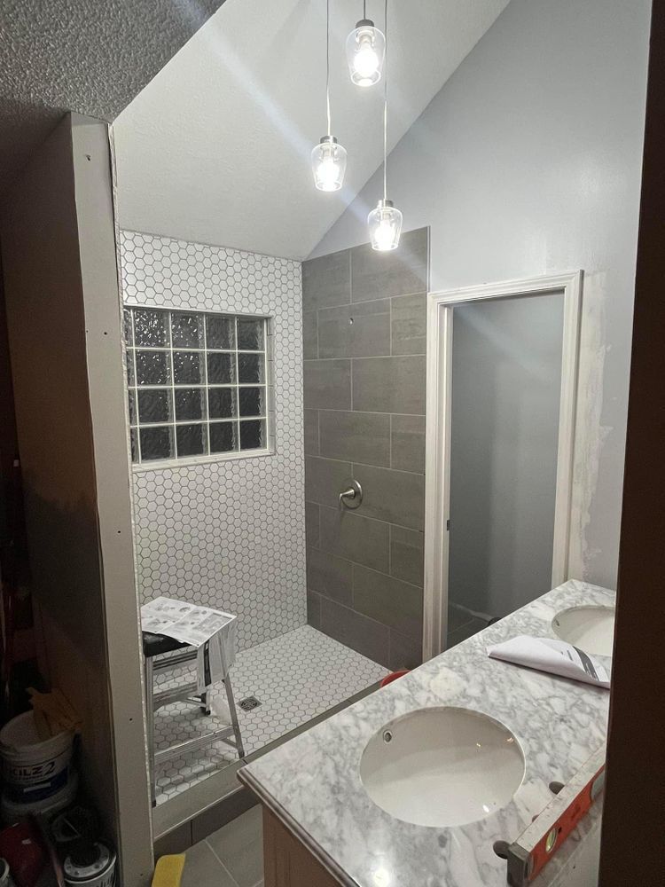 A bathroom with two sinks , a shower and a mirror.