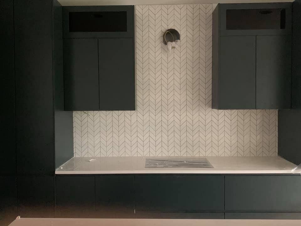 A kitchen with black cabinets and a white counter top.