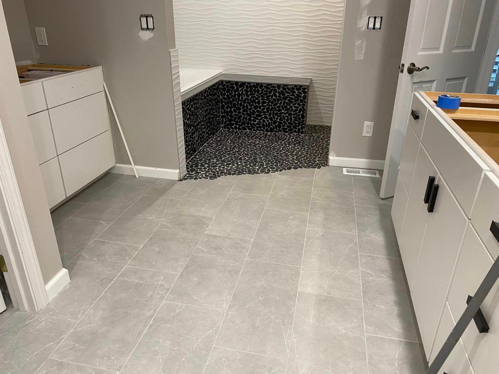 A bathroom with a tiled floor and a bathtub.