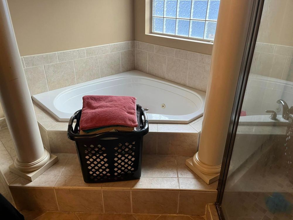 A laundry basket is sitting next to a jacuzzi tub in a bathroom.