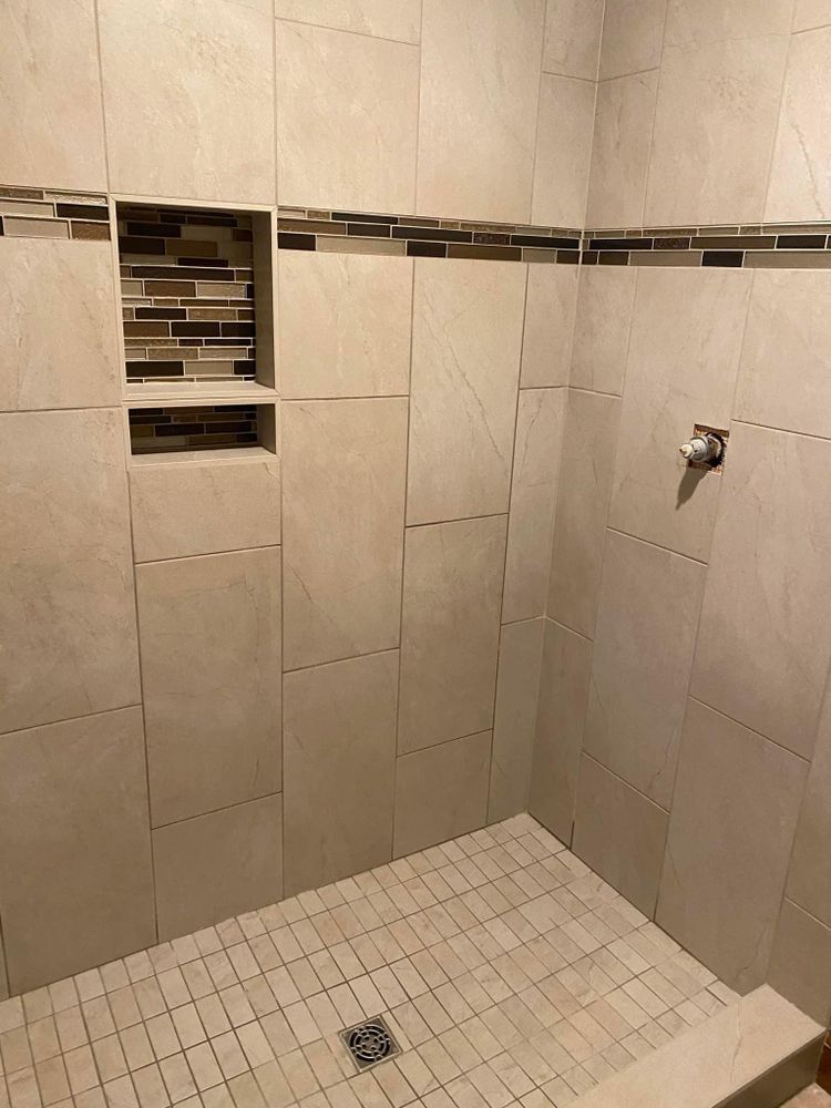 A bathroom with a walk in shower and tiled walls.