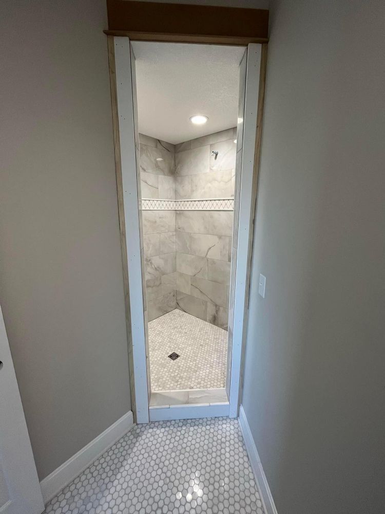A bathroom with a walk in shower and a tiled floor.