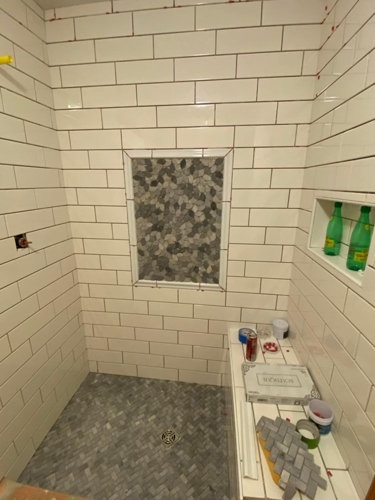 A bathroom with white tiles and a window.