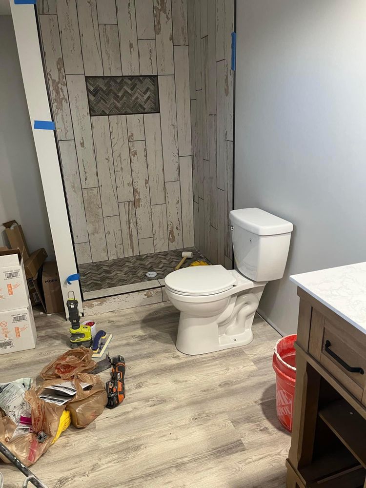 A bathroom under construction with a toilet , sink and shower.