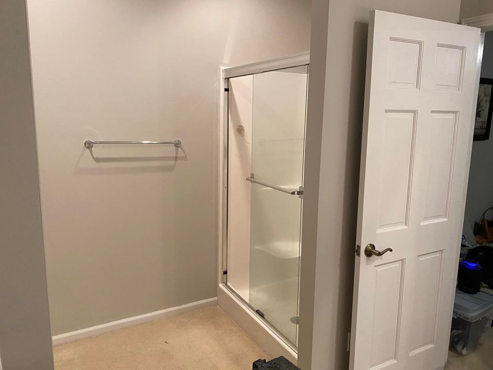 A bathroom with a walk in shower and a door.