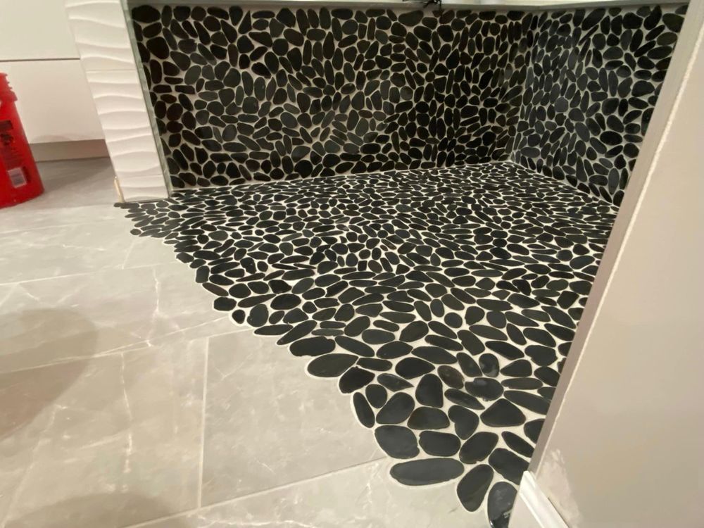 A bathroom with a black and white tile floor.