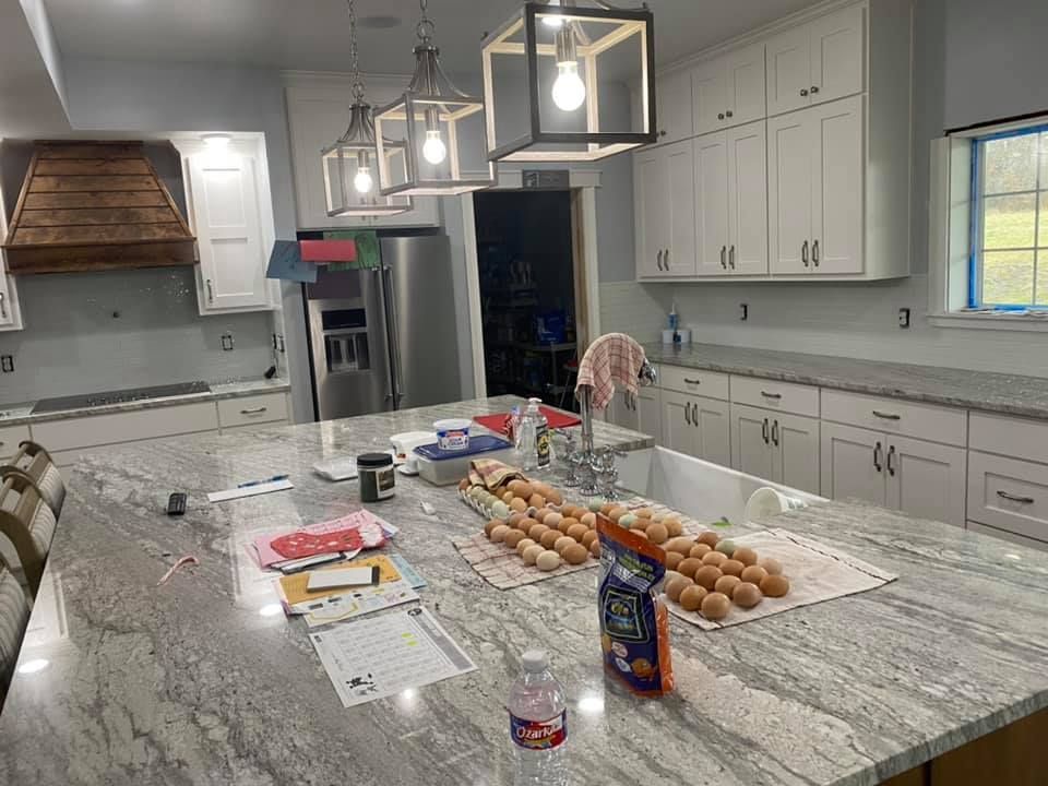 A kitchen with a large island and a lot of eggs on the counter.