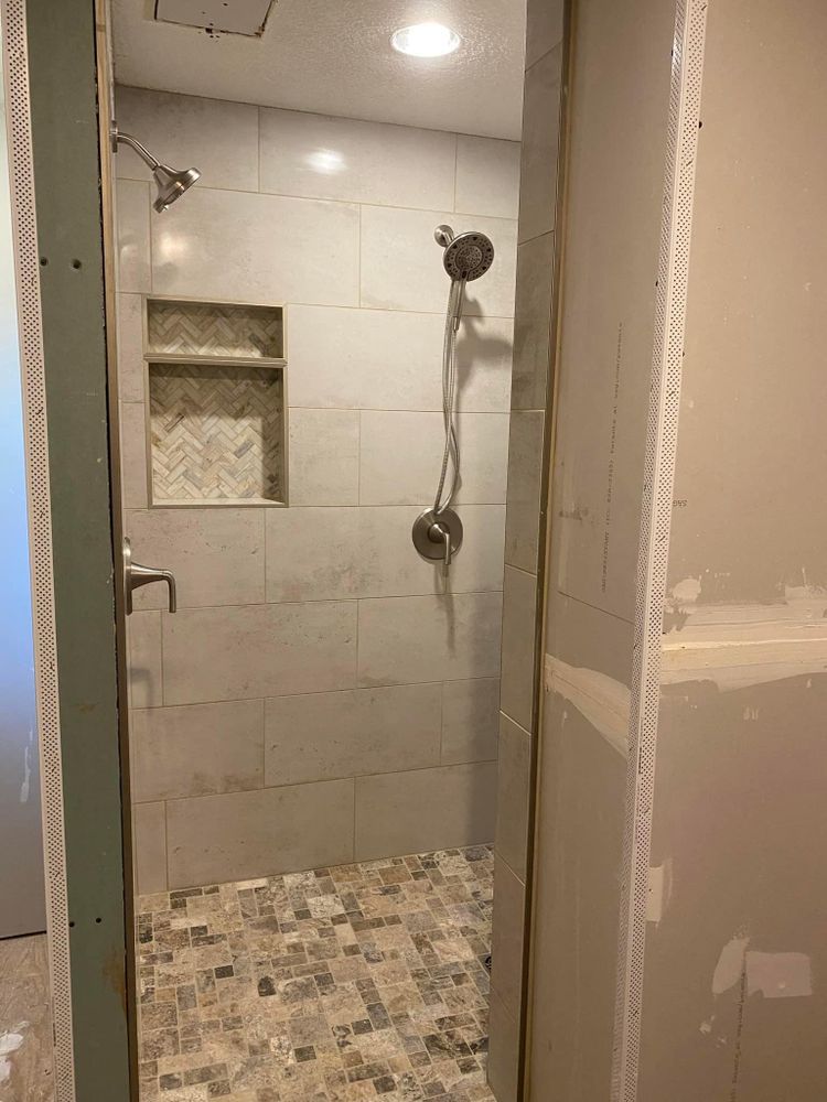 A bathroom with a walk in shower and a shower head.
