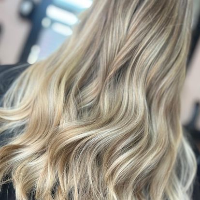 A woman is getting her hair cut at a salon.
