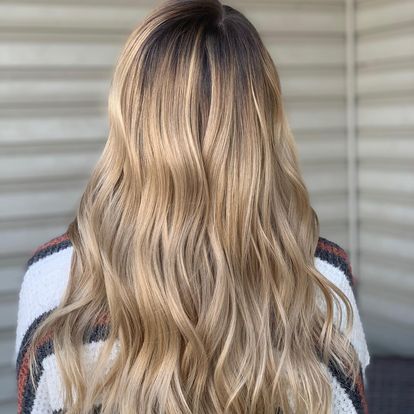 A woman with long hair is wearing a half up half down hairstyle.