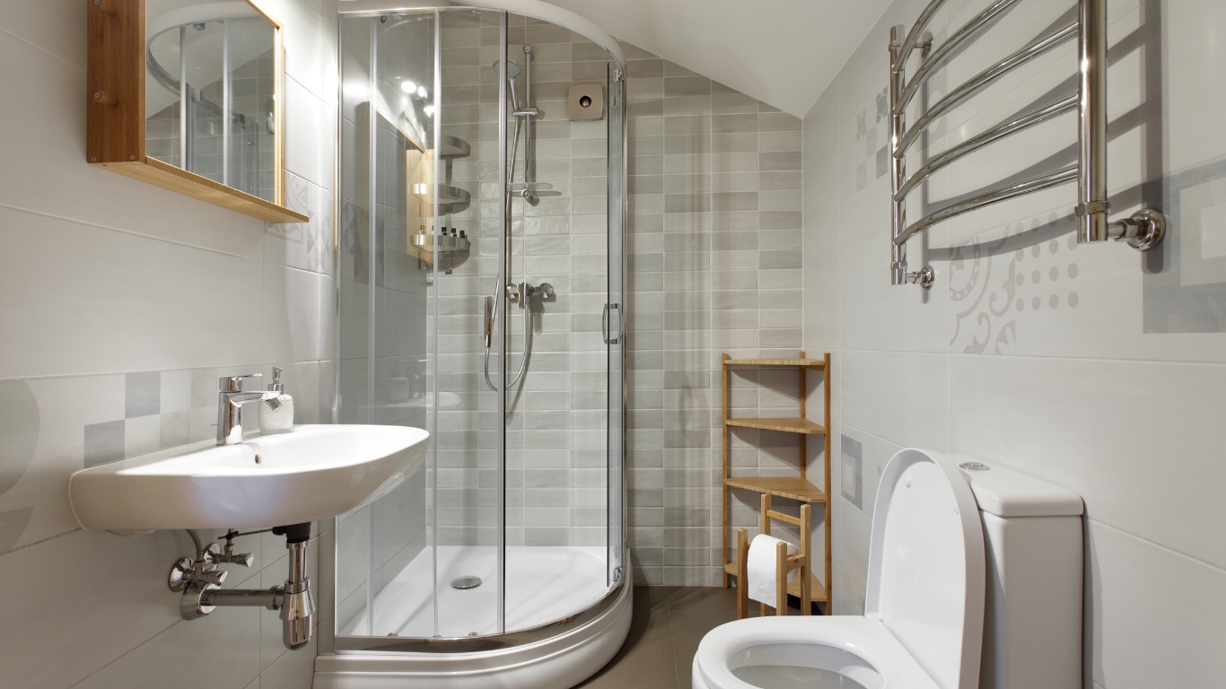 A bathroom with a toilet , sink and shower stall.