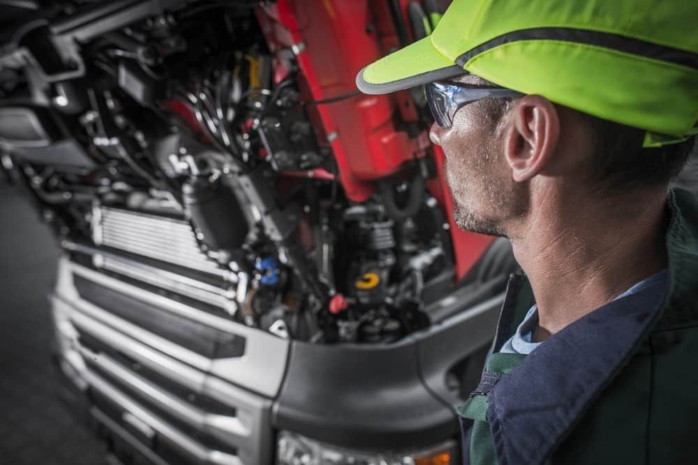 A Mechanic Is Looking Under The Hood Of A Truck — Wayne Devlin Mechanical In Bundaberg Central, QLD
