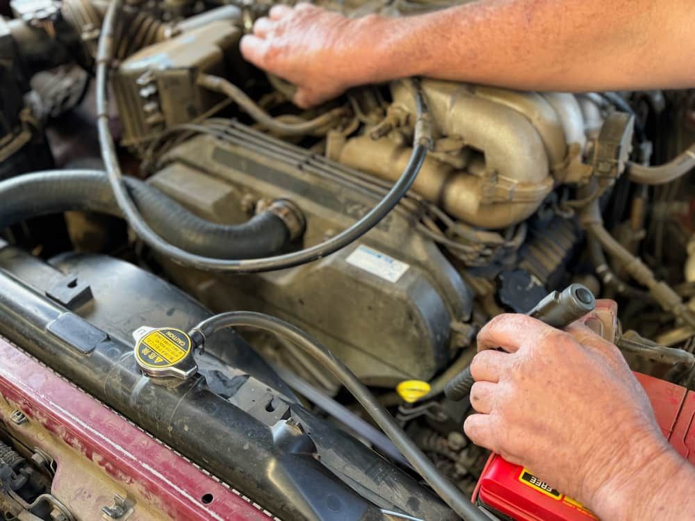 A Man Is Working On The Engine Of A Car — Wayne Devlin Mechanical In Bundaberg Central, QLD