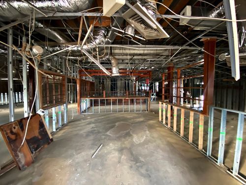 A large empty room with a lot of wires hanging from the ceiling.