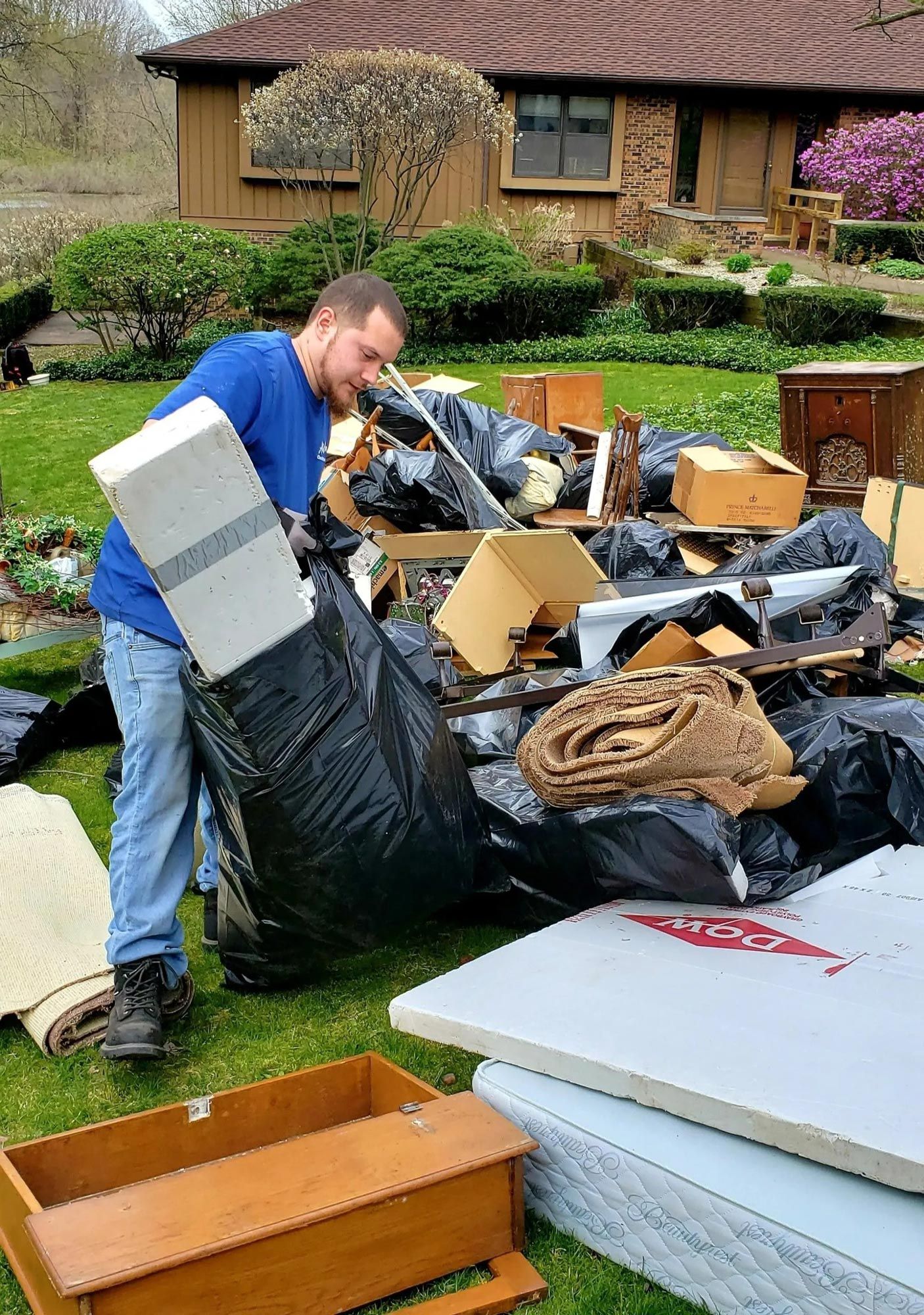 A man is standing in front of a pile of trash.