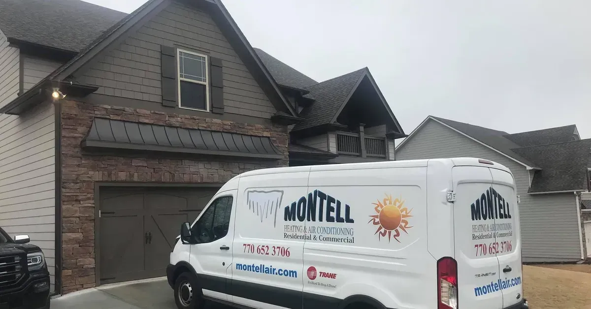 A white van is parked in front of a brick house.