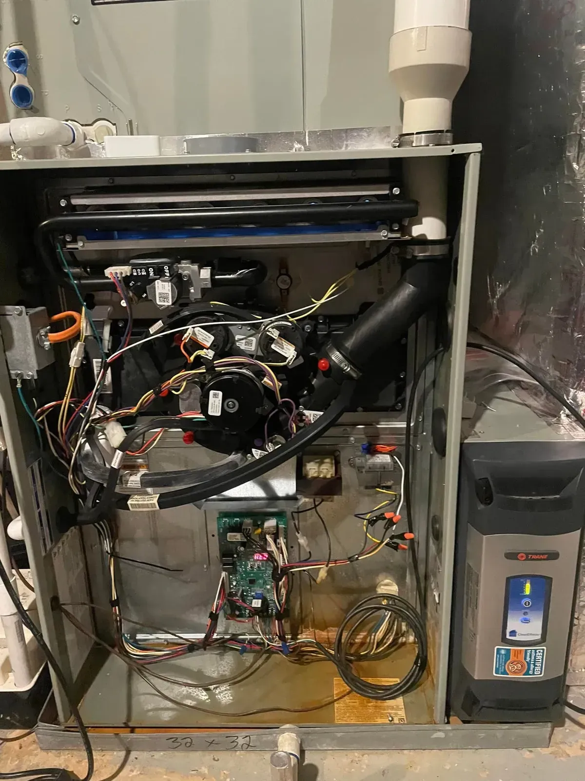 The inside of a furnace with a lot of wires coming out of it.