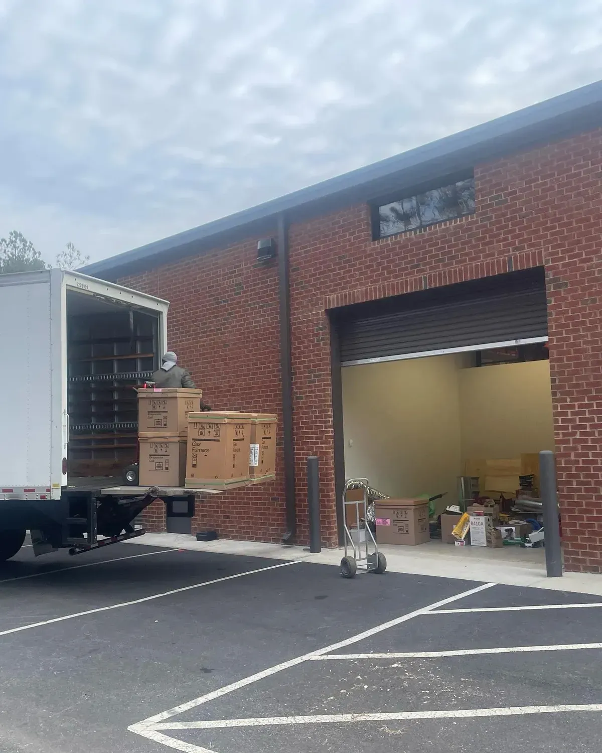 A white truck is parked in front of a brick building.