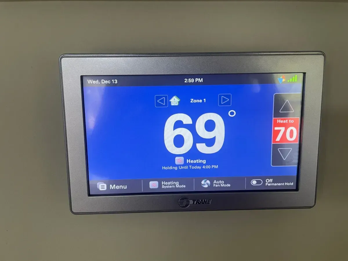 A thermostat is displaying a temperature of 69 degrees