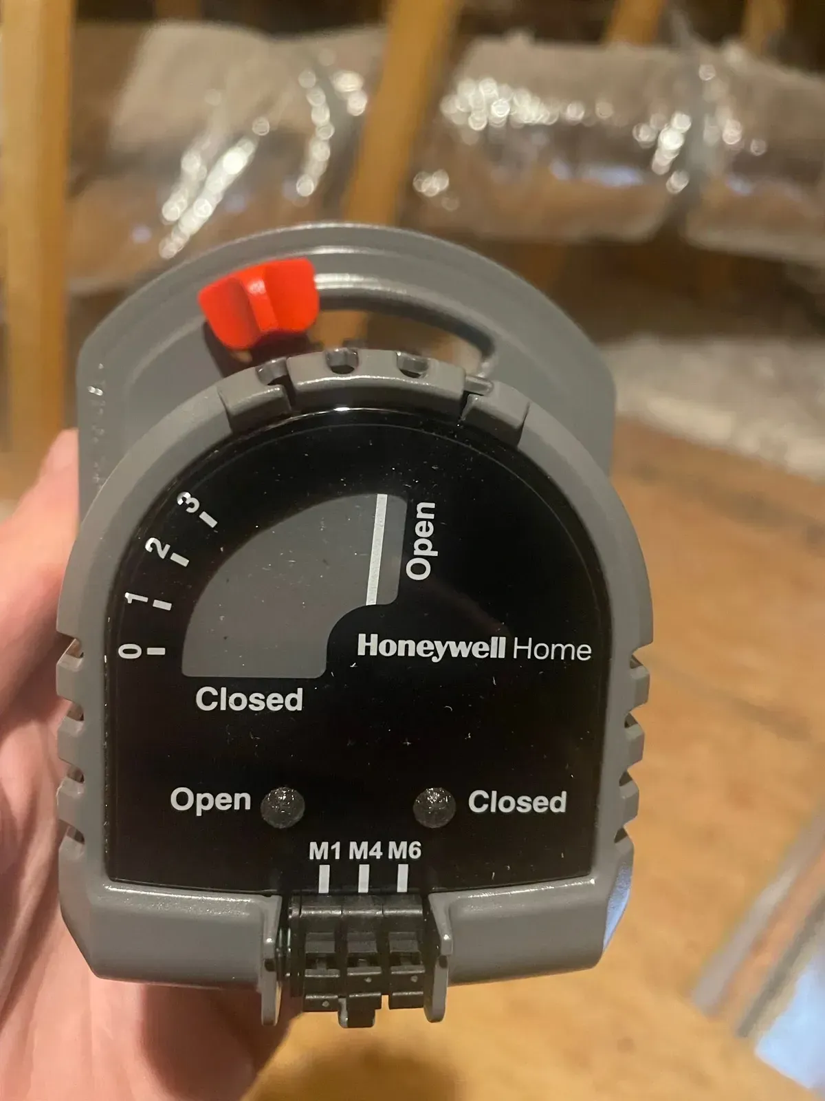 A person is holding a honeywell home device in their hand