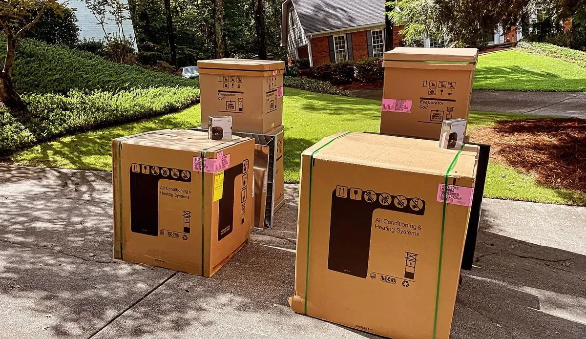 Three cardboard boxes are stacked on top of each other on a sidewalk.