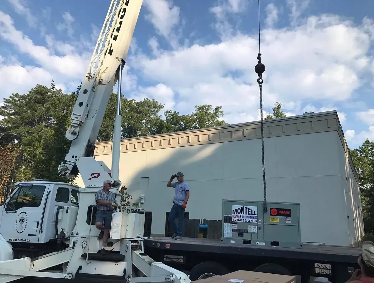 A crane is lifting a box on top of a truck.