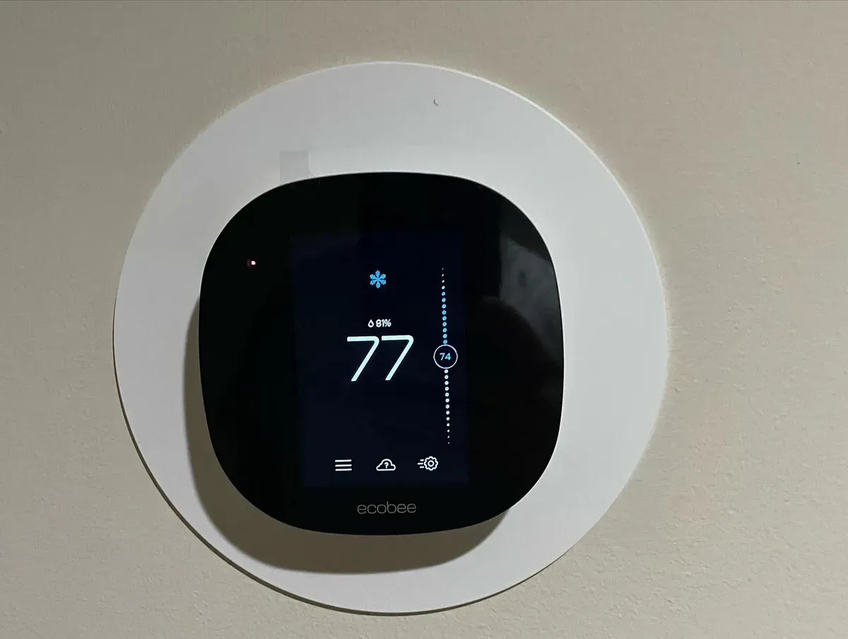 A black thermostat with the number 77 on it