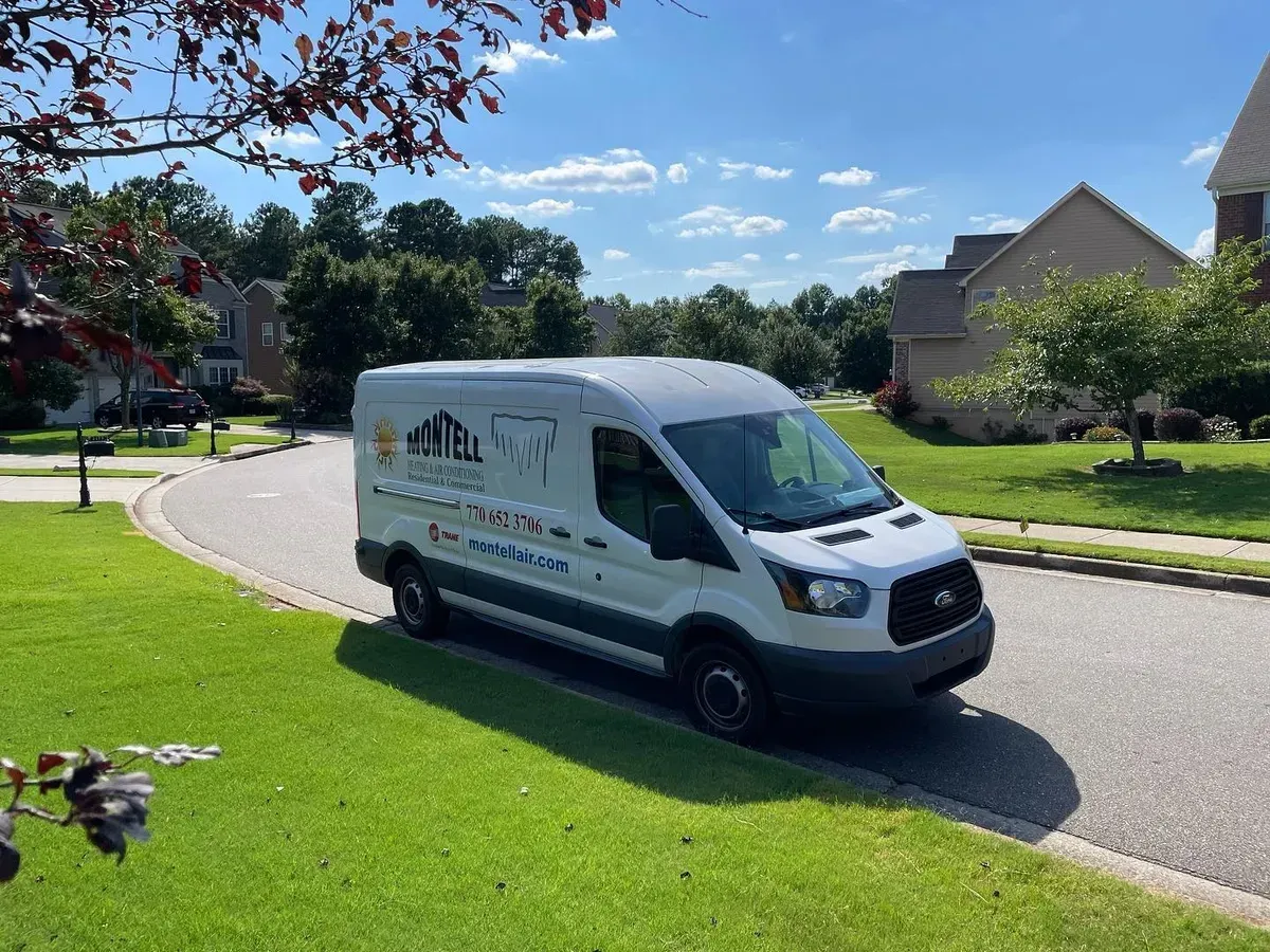 A white van is parked on the side of the road in a residential neighborhood.