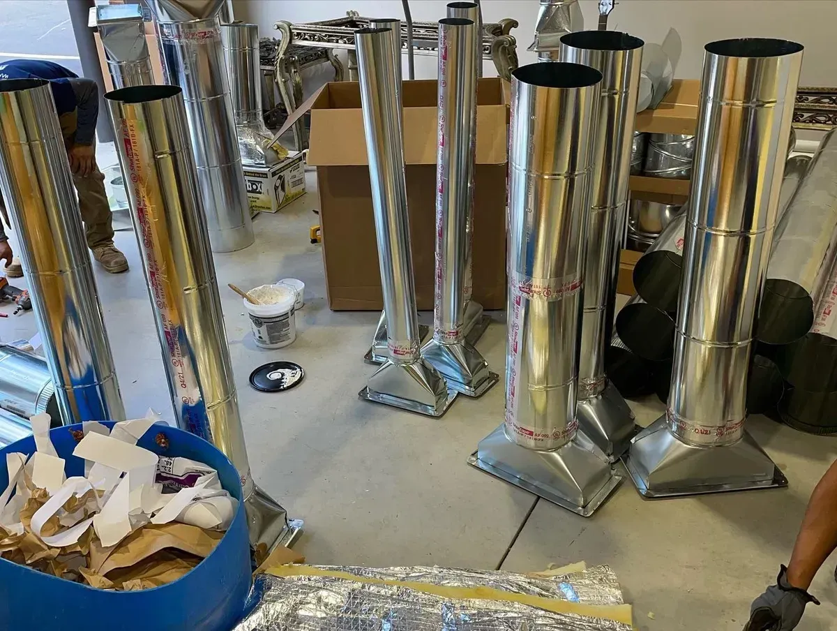 A bunch of metal pipes are sitting on the floor