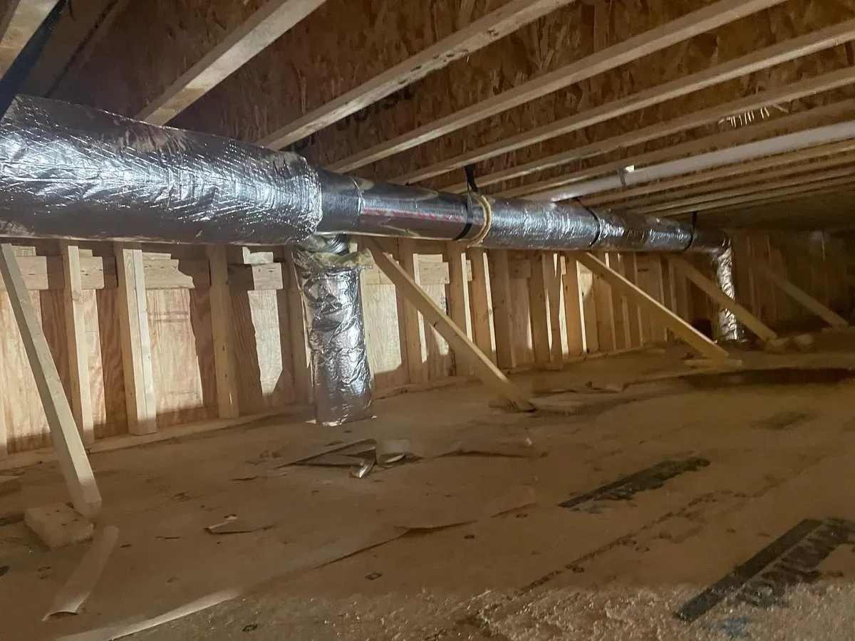 There are a lot of pipes in the attic of a house under construction.