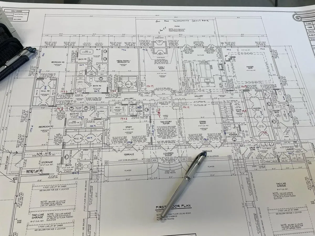 A pen is sitting on top of a drawing of a house
